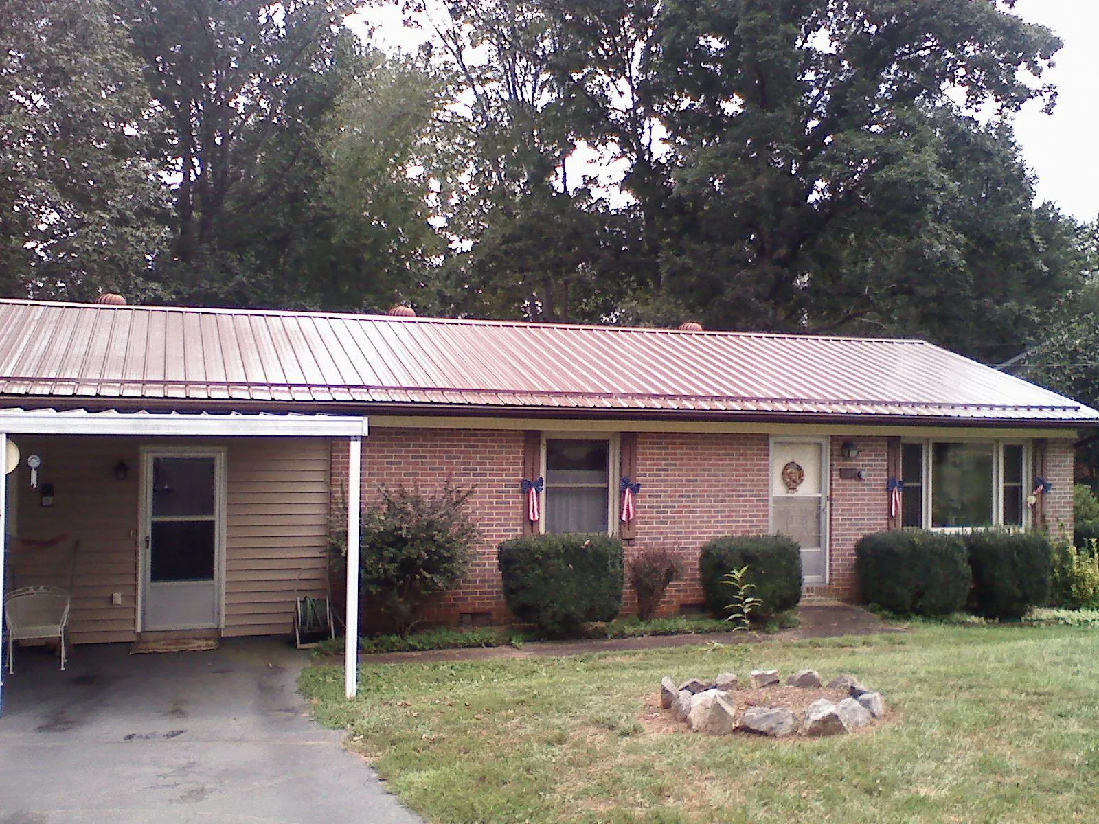 Bronze metal roof and carport on a brick ranch home — Roof Repair work by our crew in Chico